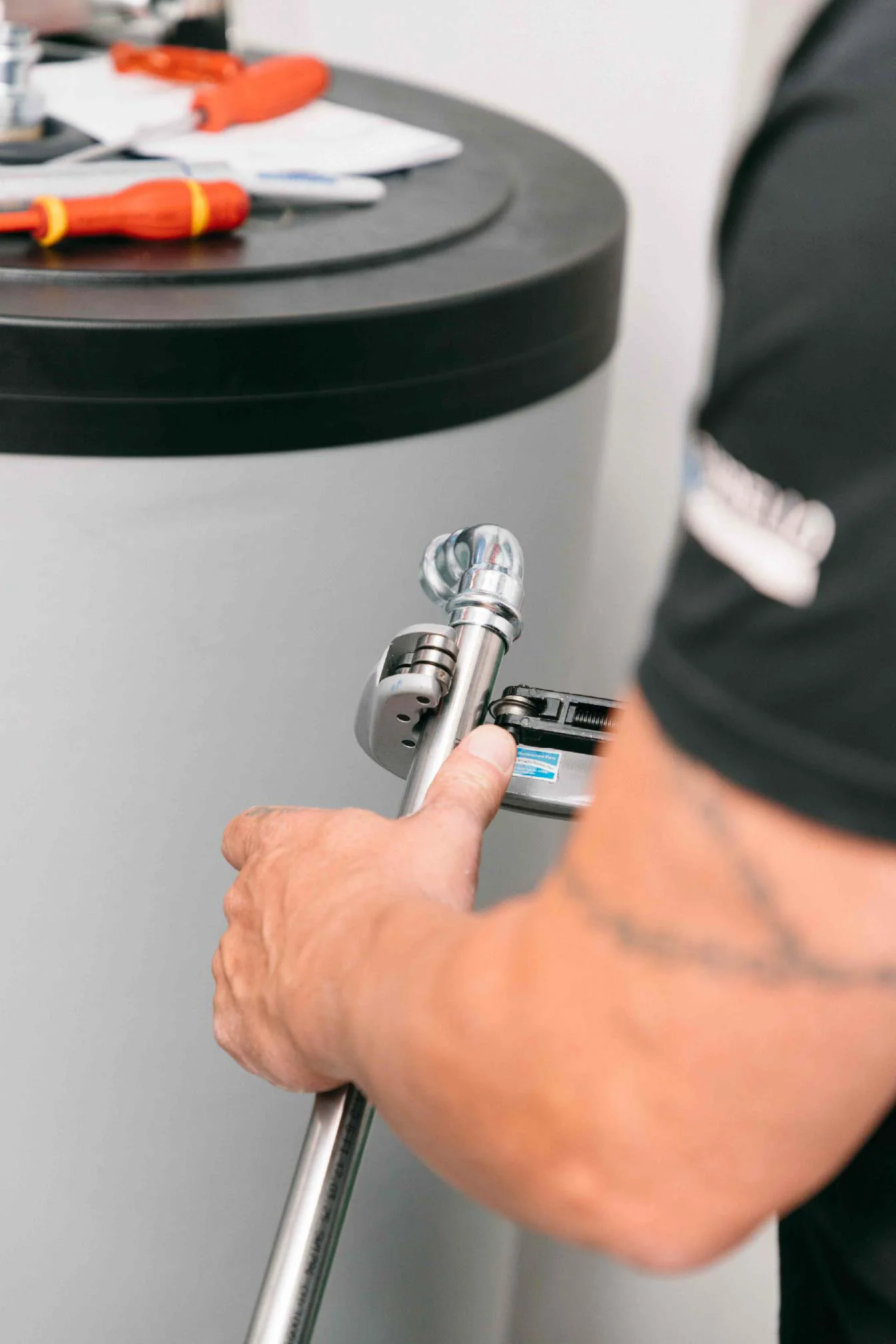 Main utilisant un outil sur un équipement cylindrique lors d’une opération de maintenance